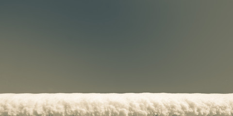 a  layer snow on a against of clear blue sky, background with copy space, tinted photo