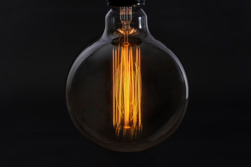 Incandescent lamp on a black background close-up. Electricity concept.