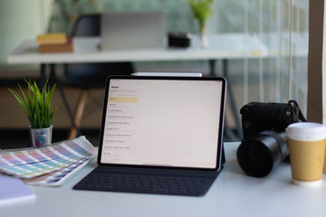 Work space on black table of photographer. Minimal workspace with Laptop, camera and lens copy space on dark background. Modern and elegant. Top view. Flat lay style. Close up.