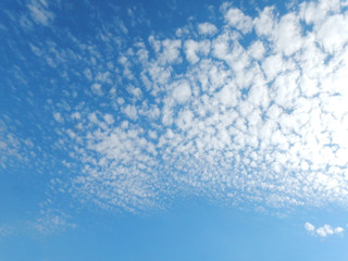 Blue sky in small and large flakes of white clouds