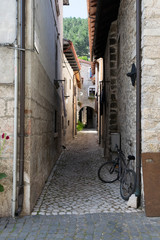 Narrow street of an Italian medieval town with a bicycle leaning against the wall
