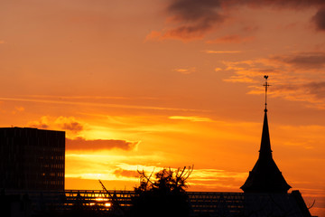 Colorful sky at sunset in Brussels. Church and modern bulding silhouettes