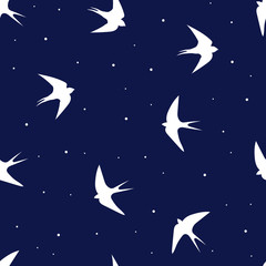 Obraz na płótnie Canvas seamless pattern of flying swallow birds on dark blue background