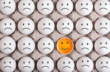 different egg stands out from the crowd and smiling.turn the disadvantage into an advantage