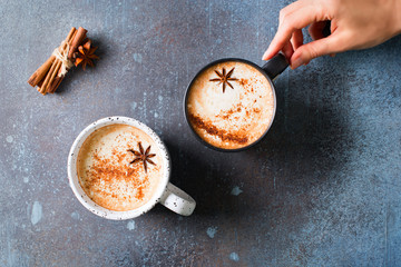 Two cups of coffee with crema, cinnamon and badian on dark background