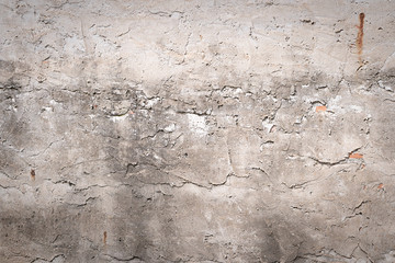 The brick wall is roughly plastered with cement. Revealing the brown brick texture inside. More texture of old dirty concrete wall for background.