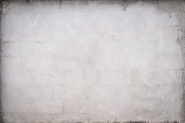 Gray concrete wall texture painted with white. The old white color that has been fading and peeling off. Texture of old dirty concrete wall for background.