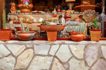 Close-up of orange ceramic vessels in the window of a souvenir shop