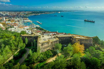 Aerial view of fortress Sao Felipe in Setubal Portugal, star shaped military base protecting the city and the harbor with bastions above the turquoise  water of the Atlantic ocean and the Sado estuary - obrazy, fototapety, plakaty