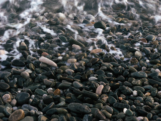 Pebble beach of rocky sea coastline. Beautiful background with pebbles
