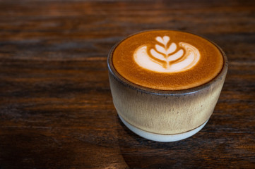 A cup of latte art coffee on wooden table
