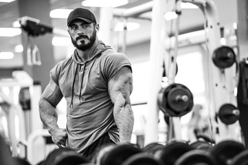 Naklejka na ściany i meble sport training motivation concept young active strong athlete male with beard posing before mirror in fitness gym club with sports equipment