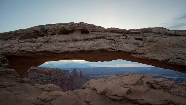 Timelapse at Mesa Arch during sunrise as the clouds start to light up before the sun peaks over the horizon in the desert.
