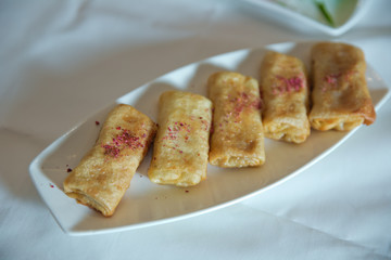 Pancakes filled with meat filling on a brown dish on plate . Pancake. Thin pancakes with fillings.