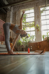 Pretty young lady doing yoga exercise at home - obrazy, fototapety, plakaty