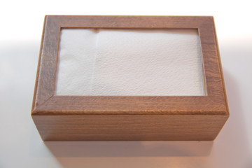 Wooden napkin holder with paper serviettes . Wooden brown empty napkin box . wooden stand with salt shaker, napkins on a wooden table in a cafe .