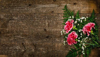 Top view of Carnation Flowers on White Vintage Wooden Background. Design concept for mothers day, wedding and valentines day with copy space. Selective focus.