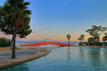 Evening landscape of the sea bay and the bridge installed across it.