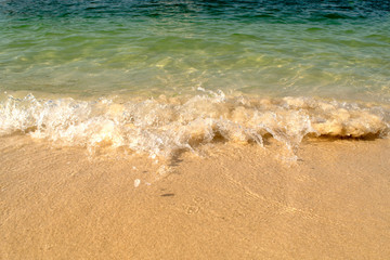 Wonderful crystal clear water on the beach. Soft sea wave on sandy beach background. Splash of water.