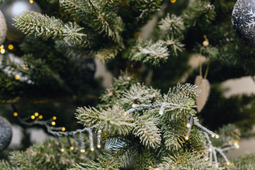 Christmas tree with decoration, lights and snow close-up background texture, Merry Christmas and a Happy New Year, bokeh and blurred colorful concept