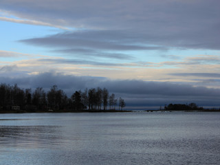 Trees at the shore of Lake Vanern and autumn clouds.