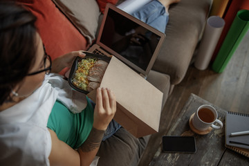 Young female having lunch break at home