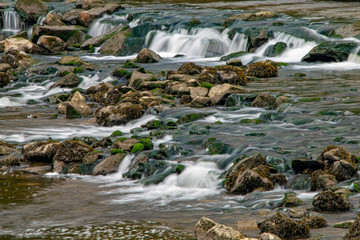Fototapeta na wymiar River Meavy water flowing over rocks at Lopwell Weir, Plymouth, Devon