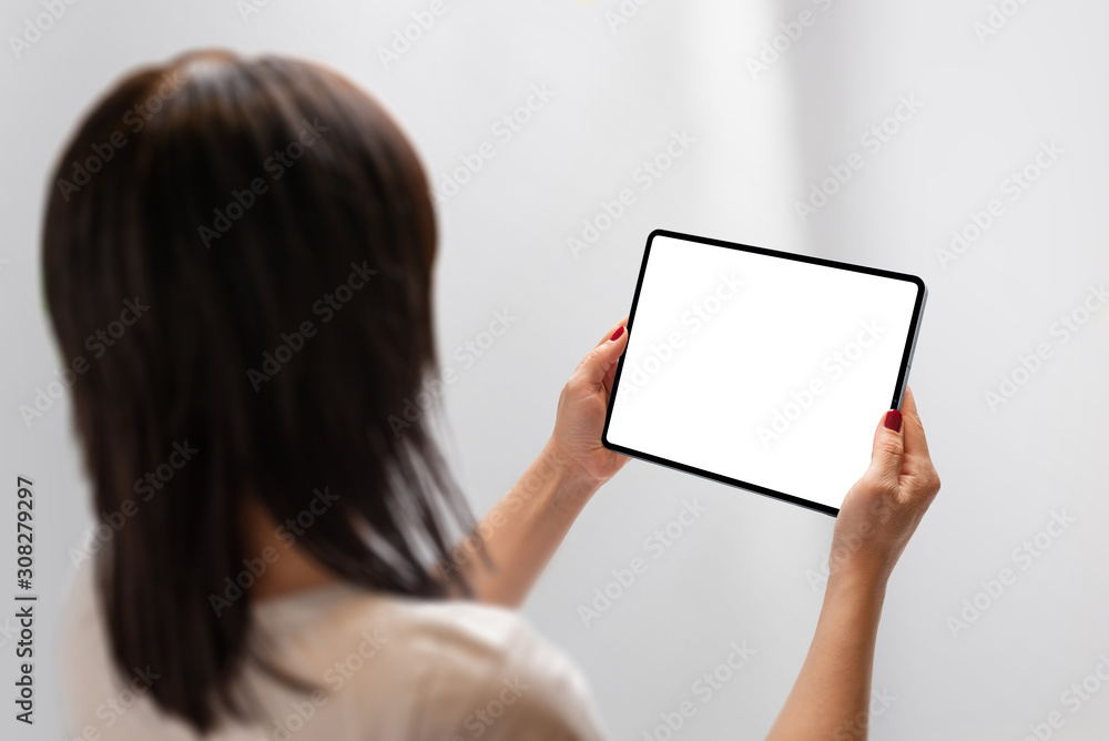 Poster girl holding tablet with isolated screen for mockup. moder tablet with thin edges. view over shoulde