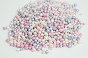 heap of colorful sugar sprinkles in white, pink and blue