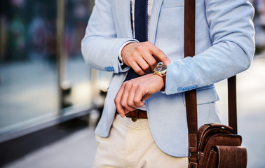 Always on time. Businessman looking at his watch on the way to office. Business, lifestyle concept