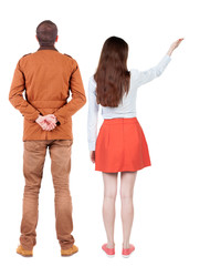 Back view of a stylish couple pointing.