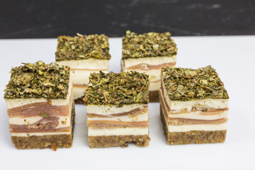 appetizer of layers of cream cheese and serrano ham on whole grain bread