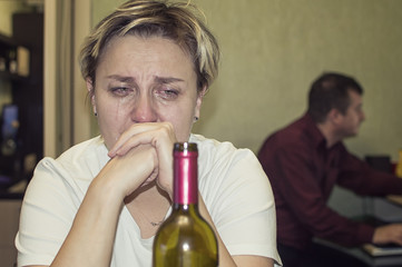 a married woman cries and drinks alcohol. female alcoholism.selective focus. film grain.