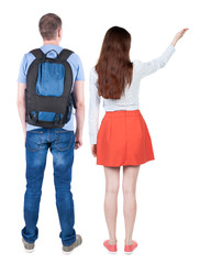 Back view of a stylish couple pointing.