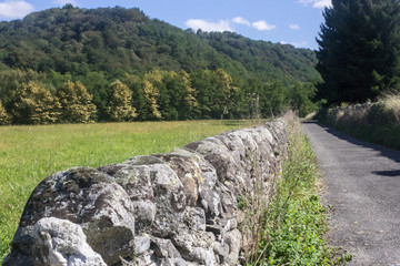 Roman wall along the way. Ancient masonry. Path pilgrim Camino de Santiago. Hiking in Europe. Walking route. Route through the plains and fields. Traveling with a backpack.