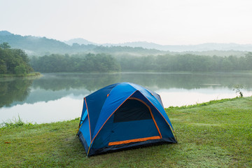 Camping tent by a lake with mist at sunrise Jedkod-Pongkonsao Natural Study in Saraburi Province Thailand