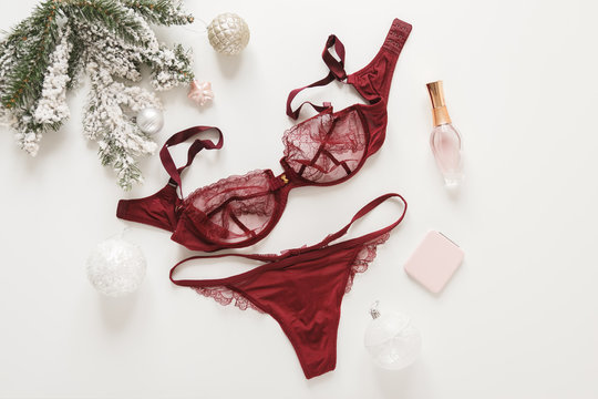 Red lace lingerie and perfume bottle. Top view. Gift set of women's accessories and underwear on flat lay.