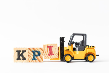 Toy forklift hold wood letter block I to complete word KPI (Abbreviation of Key performance...