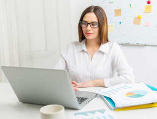 Young business woman works at a computer.