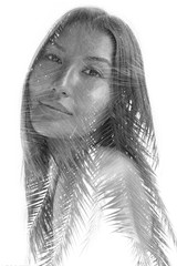 Double exposure portrait of a young ethnic beauty combined with tree leaves, black and white