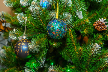 Background of Christmas fir decorated with balls. New year tree dressed up.