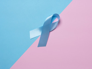 On multi-colored backgrounds pink and blue satin ribbon symbol of prostate cancer awareness....