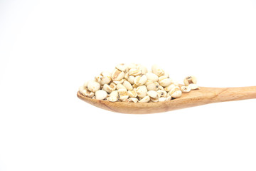 Millet grain in the wooden spoon isolated on a white background.