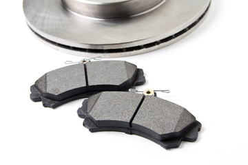 Brake pads and brake discs for cars isolated on white background. New car parts.