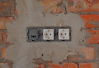 Electrical Outlet Plug Mounted In Brick Wall 