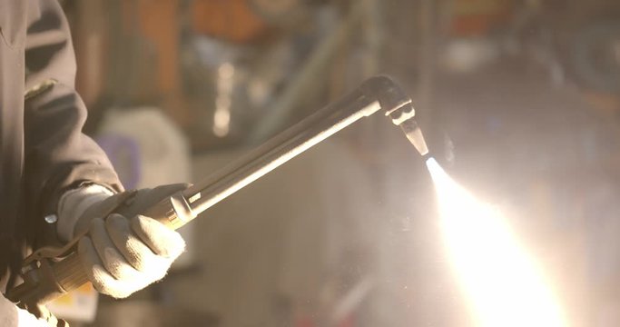Worker lights a welding torch creating a giant flame