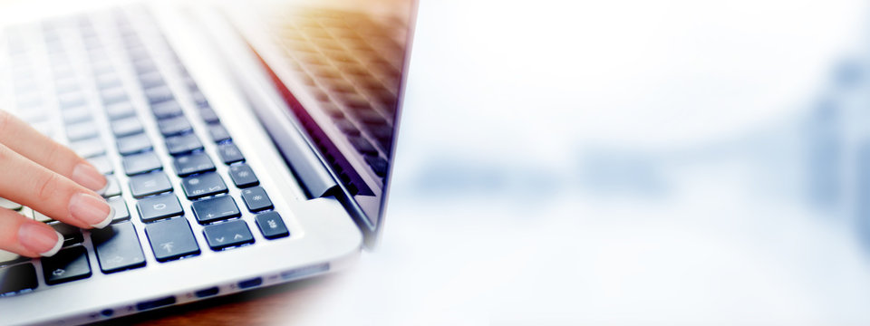 Business woman working on modern computer banner or panorama. Person buying online at internet. Laptop keyboard detail with hands copy space for text.