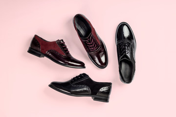 Black and bordeaux patent female shoes on bright pink background. Flat lay, top view.