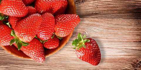 Fresh red strawberries in bowl. Strawberry fruits on wooden old table copy space. Banner or...