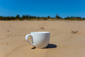 beautiful closeup porcelain coffee cup on the sand
